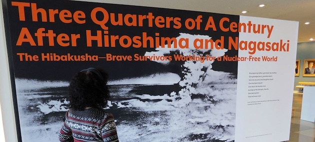 Erico Platt looks at the disarmament exhibition that she staged, "Three Quarters of a Century After Hiroshima and Nagasaki: The Hibakusha—Brave Survivors Working for a Nuclear-Free World." Credit: UNODA/Diane Barnes